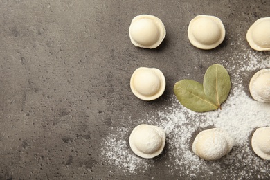 Raw dumplings on grey background, flat lay with space for text