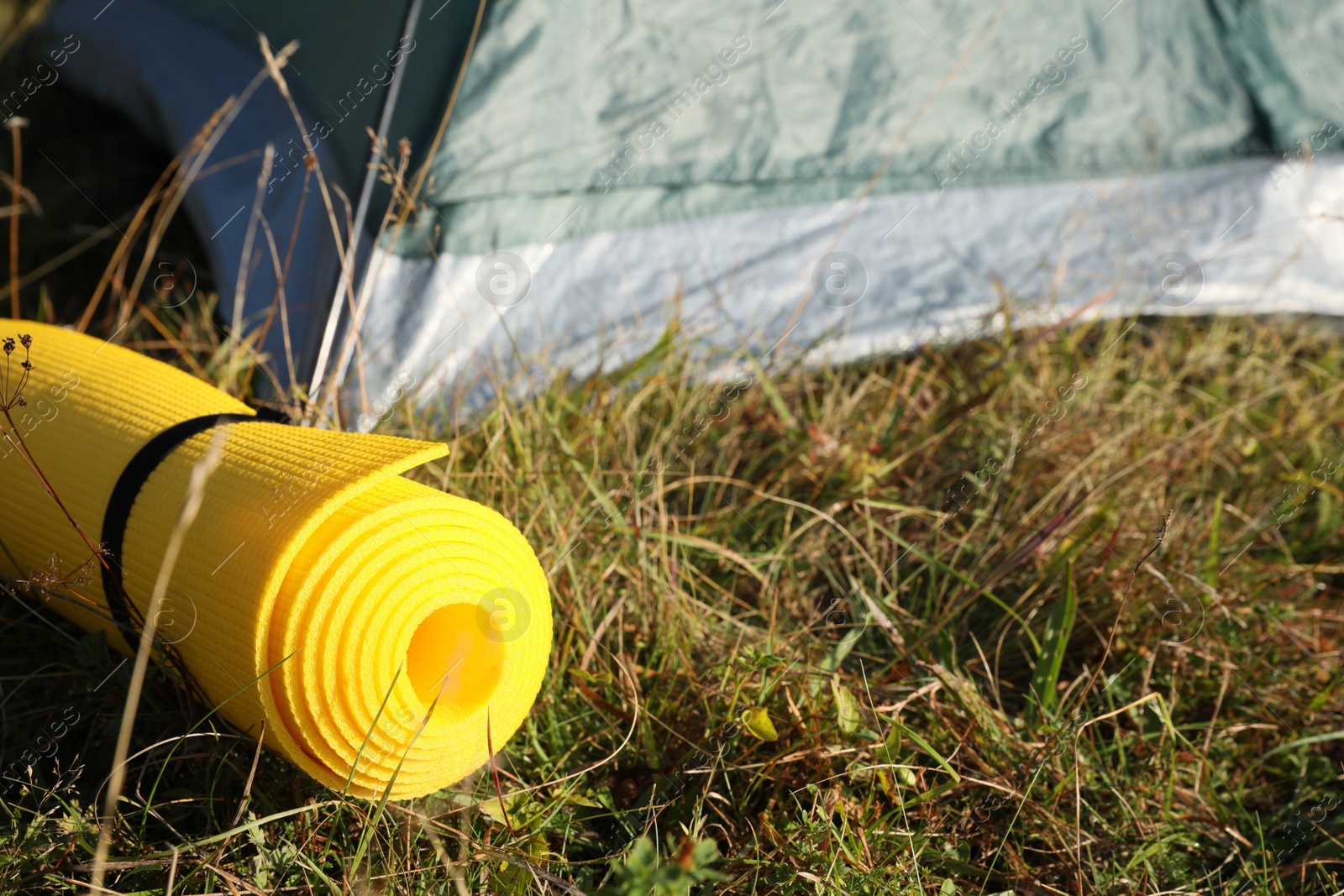 Photo of Sleeping mat near camping tent outdoors. Tourism equipment