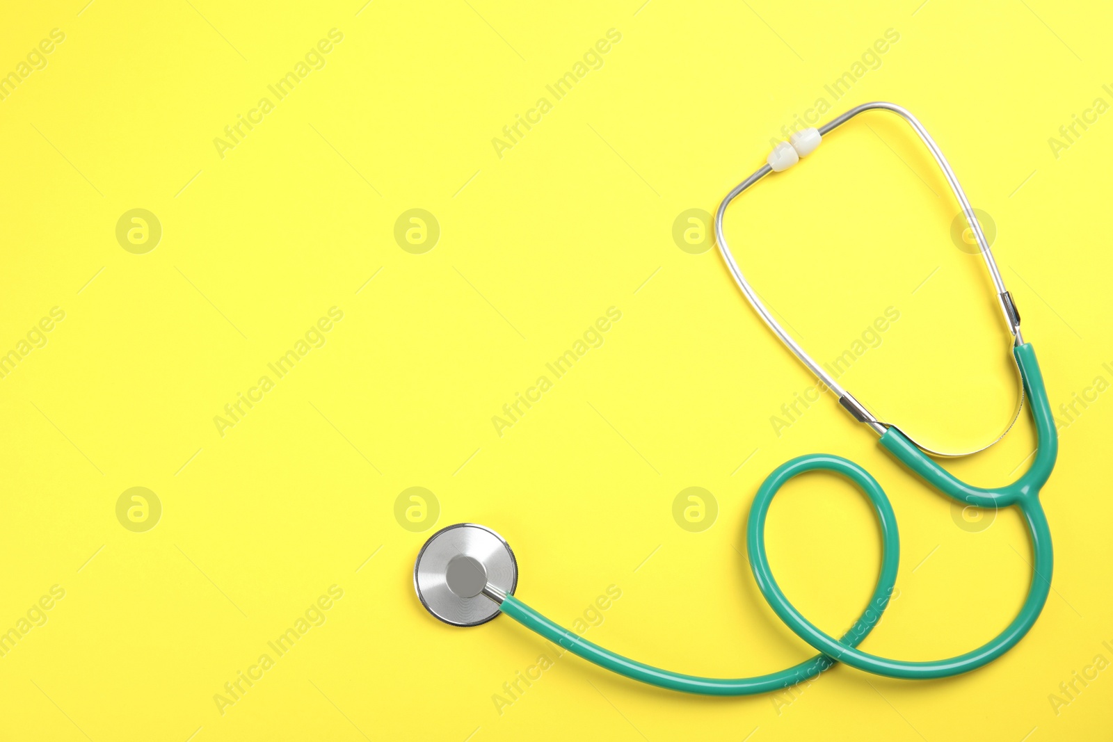 Photo of Stethoscope with space for text on color background, top view. Medical tool