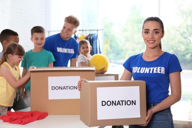 Photo of Volunteers with children sorting donation goods indoors