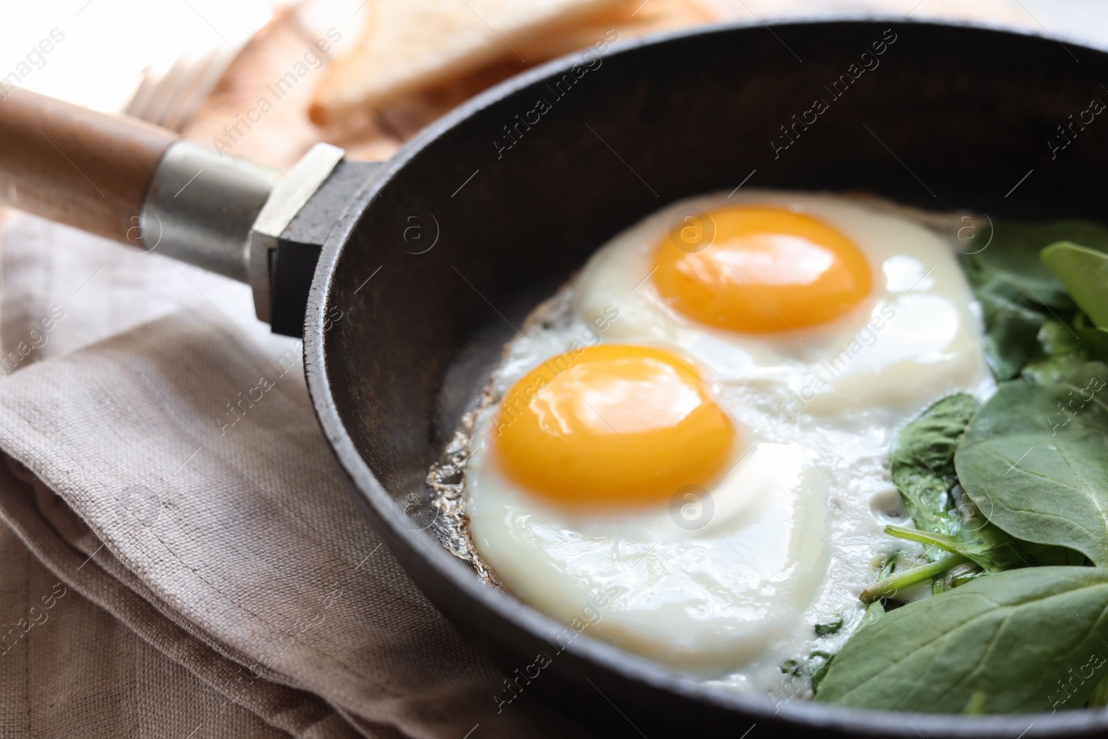 Photo of Delicious fried egg with spinach served on wooden table, closeup