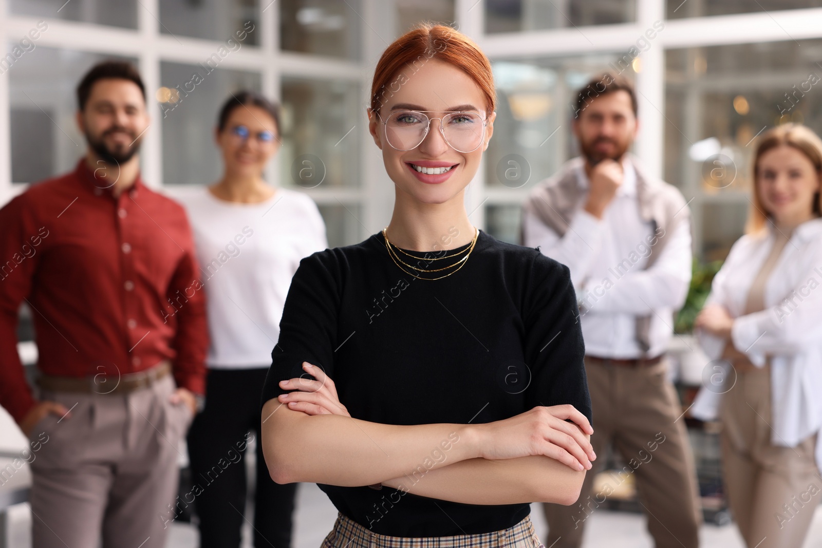 Photo of Portrait of happy businesswoman and her team in office