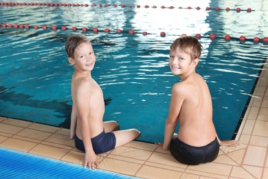 Photo of Cute little boys near indoor swimming pool