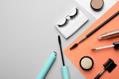 Photo of Flat lay composition with false eyelashes and other makeup products on color background, space for text