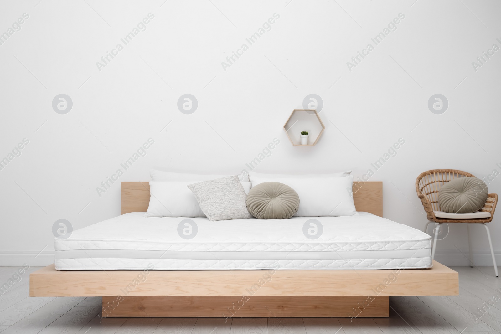 Photo of Wooden bed with soft white mattress and pillows indoors