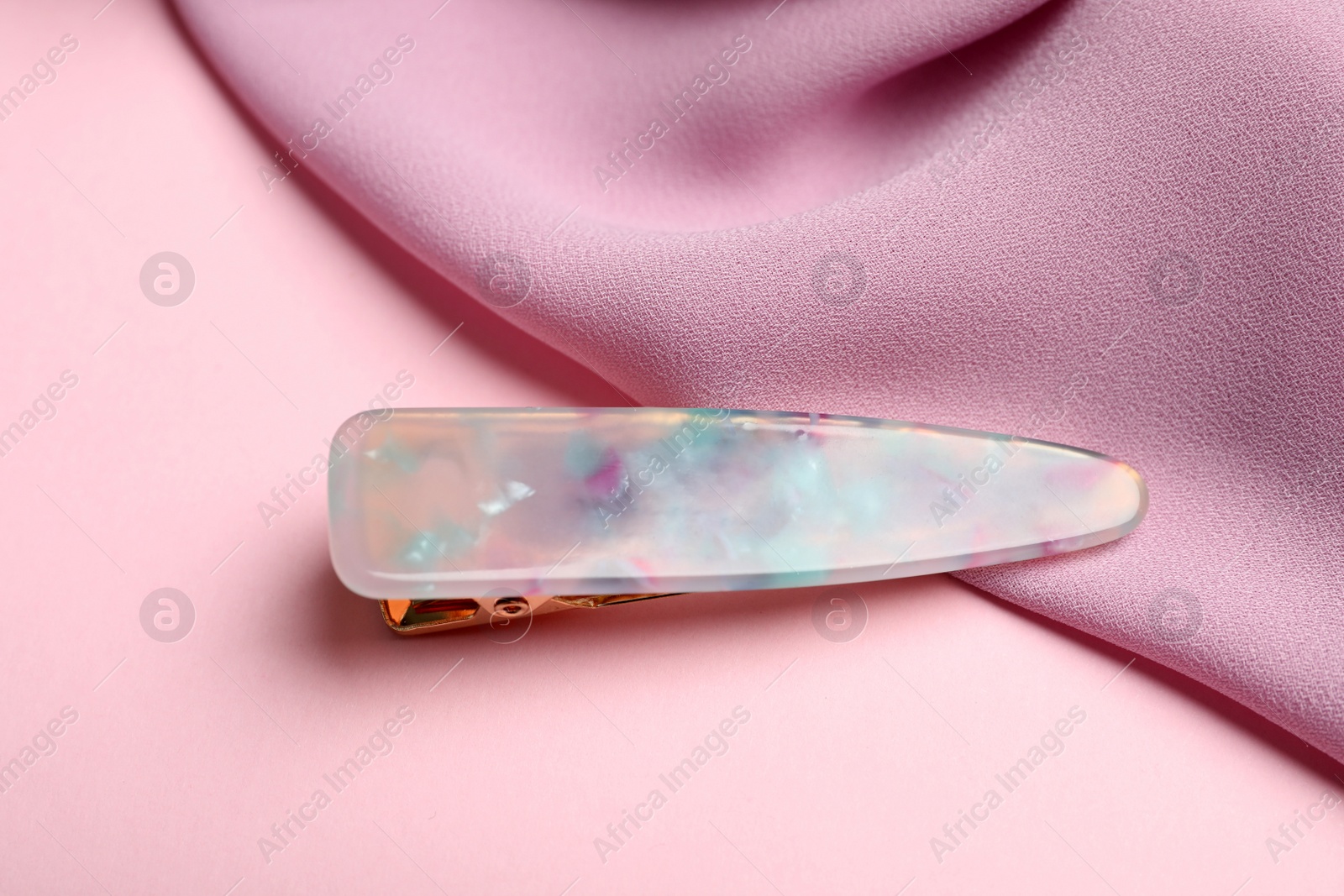 Photo of Stylish hair clip and fabric on pink background, above view