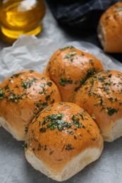 Photo of Traditional pampushka buns with garlic and herbs on table, closeup