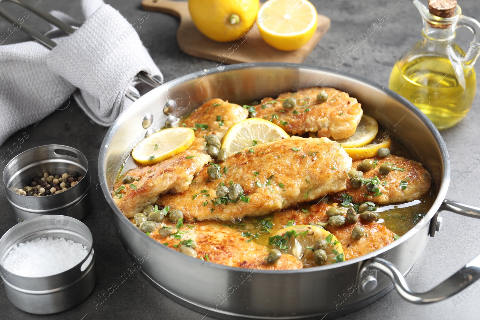 Photo of Delicious chicken piccata on grey table, closeup