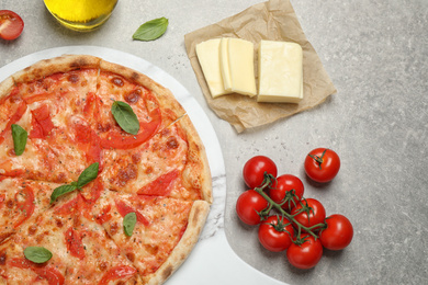 Photo of Delicious pizza Margherita and ingredients on light grey table, flat lay