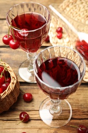 Photo of Delicious cherry wine with ripe juicy berries on wooden table
