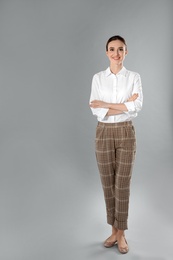 Photo of Full length portrait of young female teacher on grey background