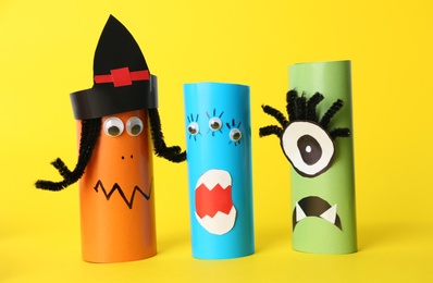 Photo of Funny monsters on yellow background. Halloween decoration