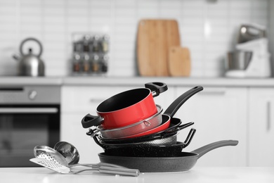 Set of clean cookware and utensils on table in kitchen