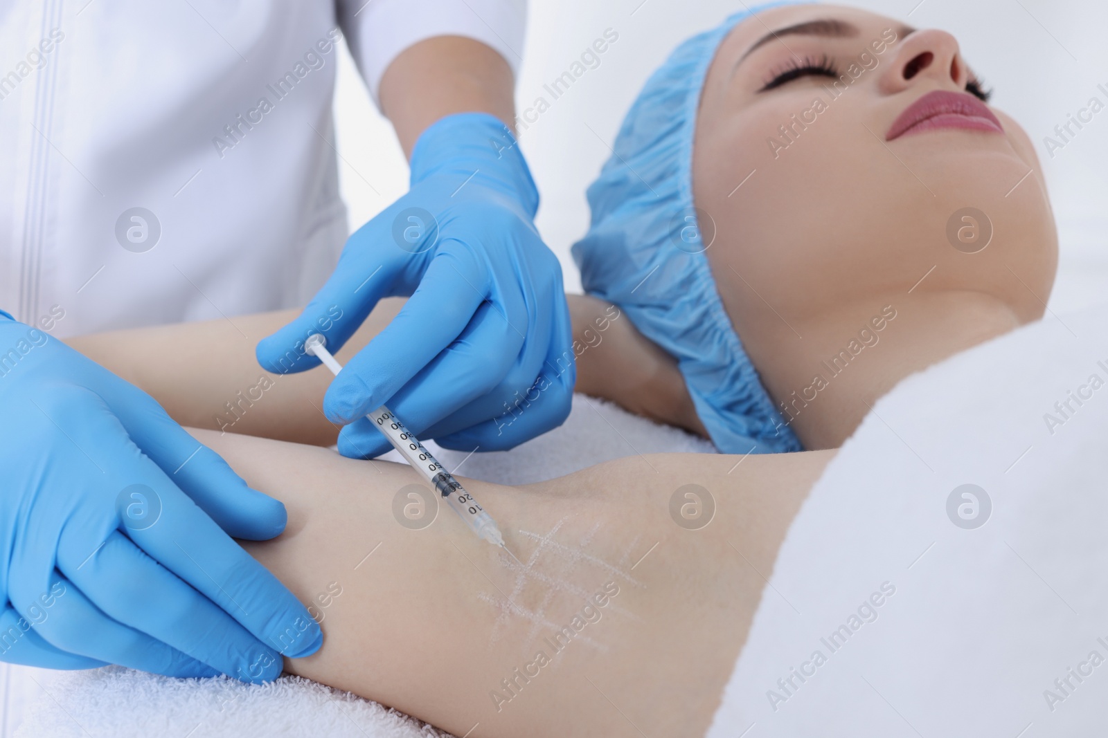 Photo of Cosmetologist injecting young woman's armpit, closeup. Treatment of hyperhidrosis