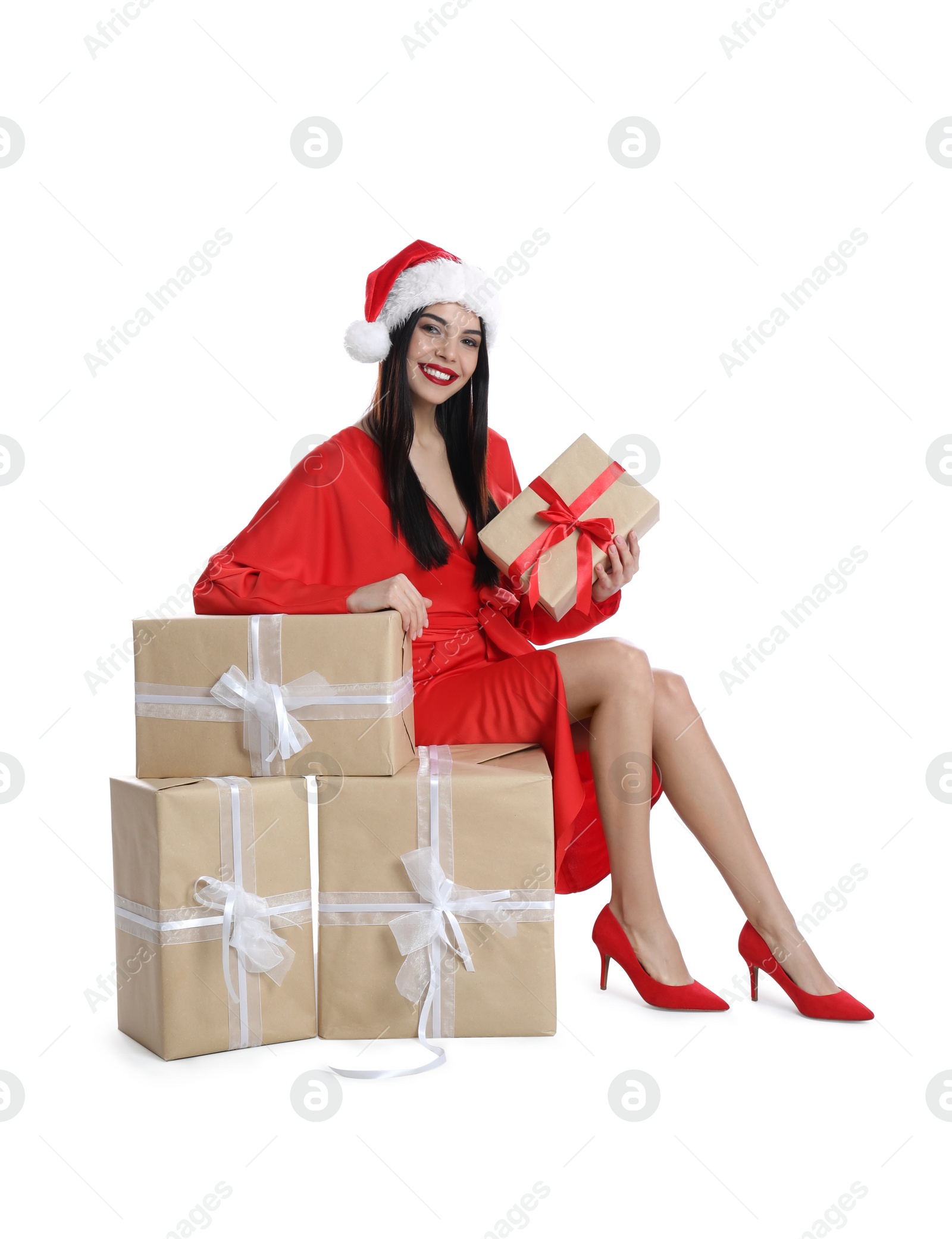 Photo of Woman in red dress and Santa hat with Christmas gifts on white background