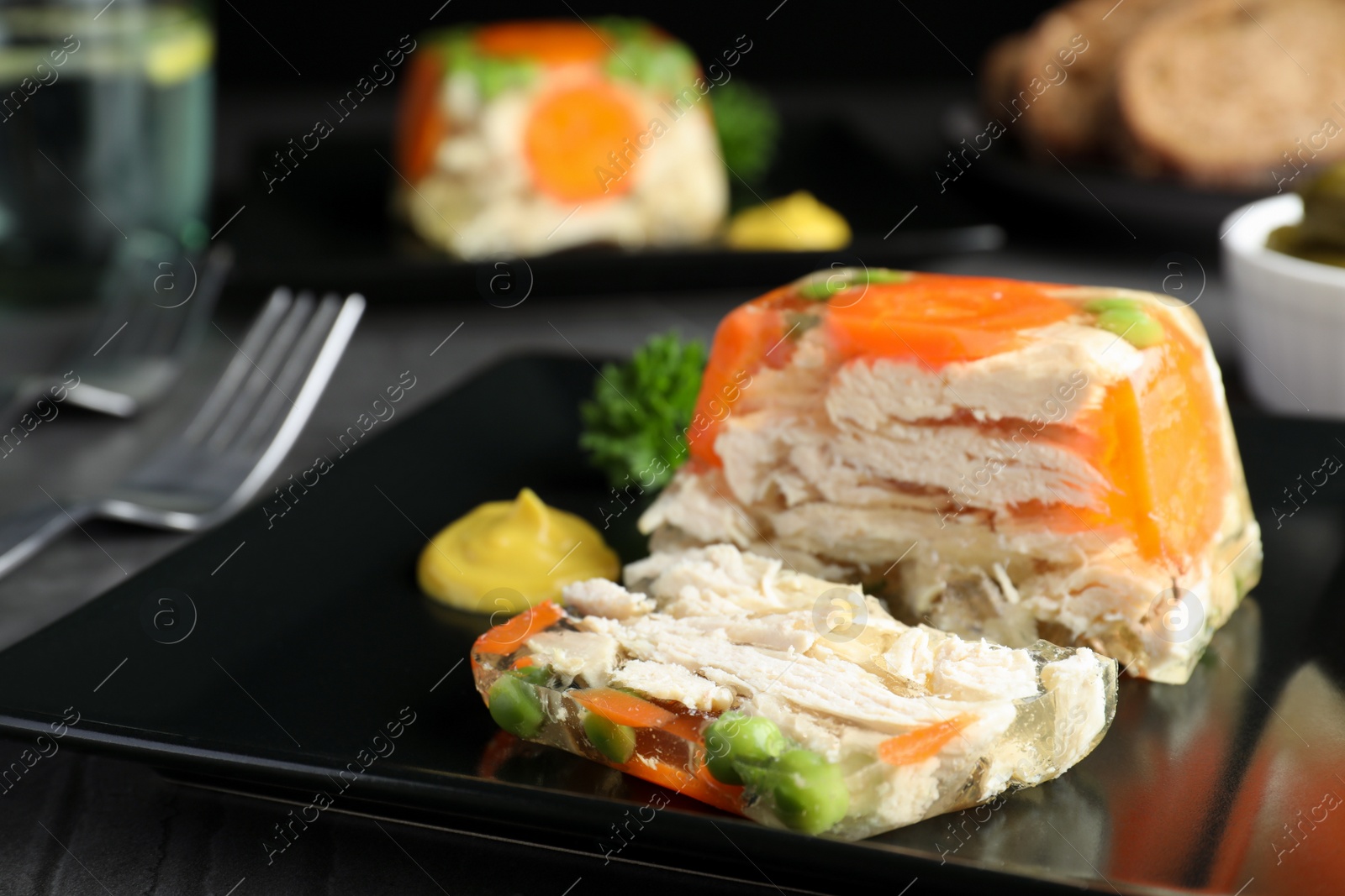 Photo of Delicious chicken aspic served on black table, closeup