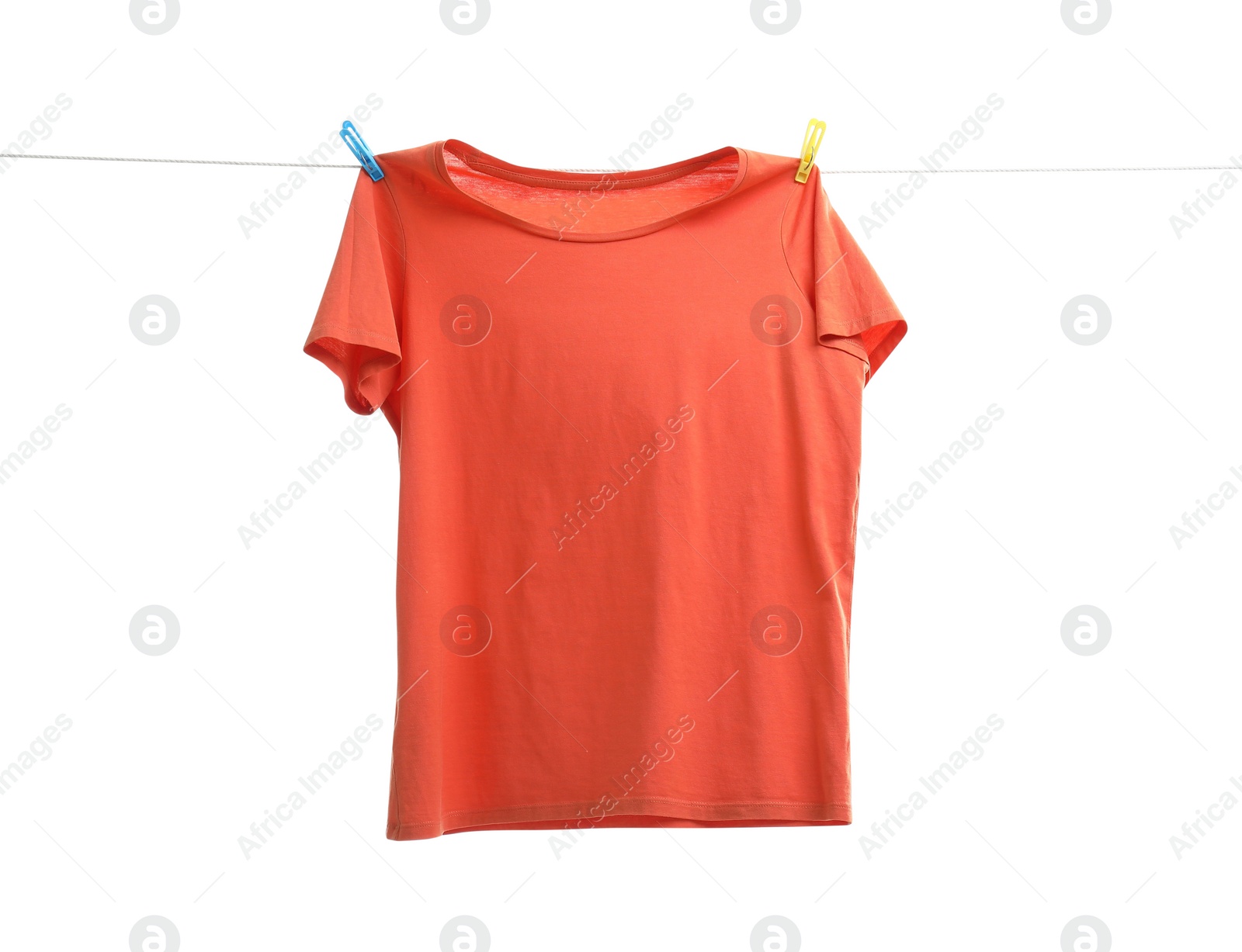 Photo of One orange t-shirt drying on washing line isolated on white