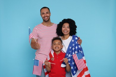 Photo of 4th of July - Independence Day of USA. Happy family with American flags on light blue background