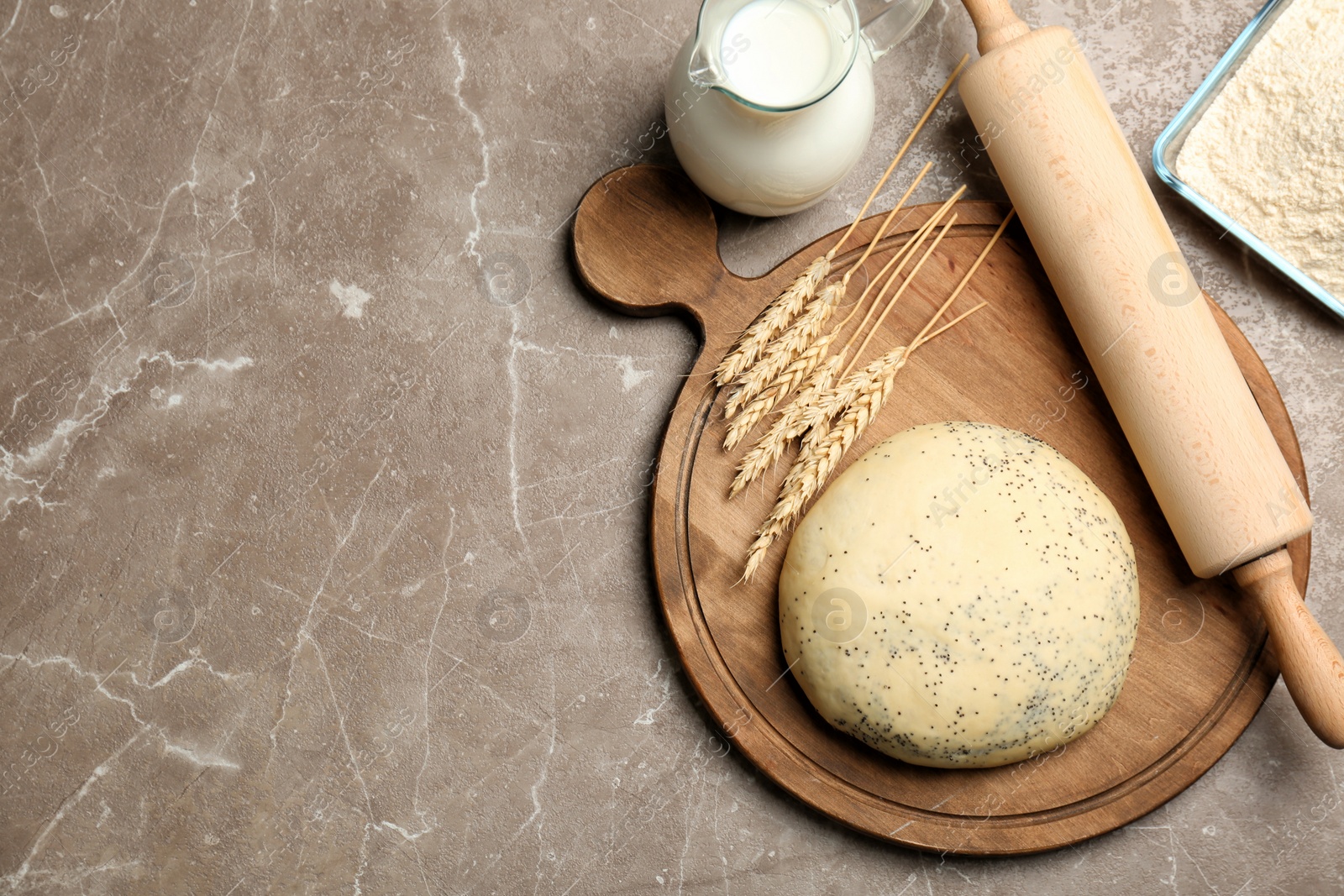 Photo of Composition of raw dough with poppy seeds on table