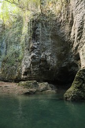 Photo of Picturesque view of clean river near cliffs and plants outdoors