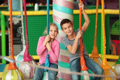 Photo of Cute little children playing at indoor amusement park