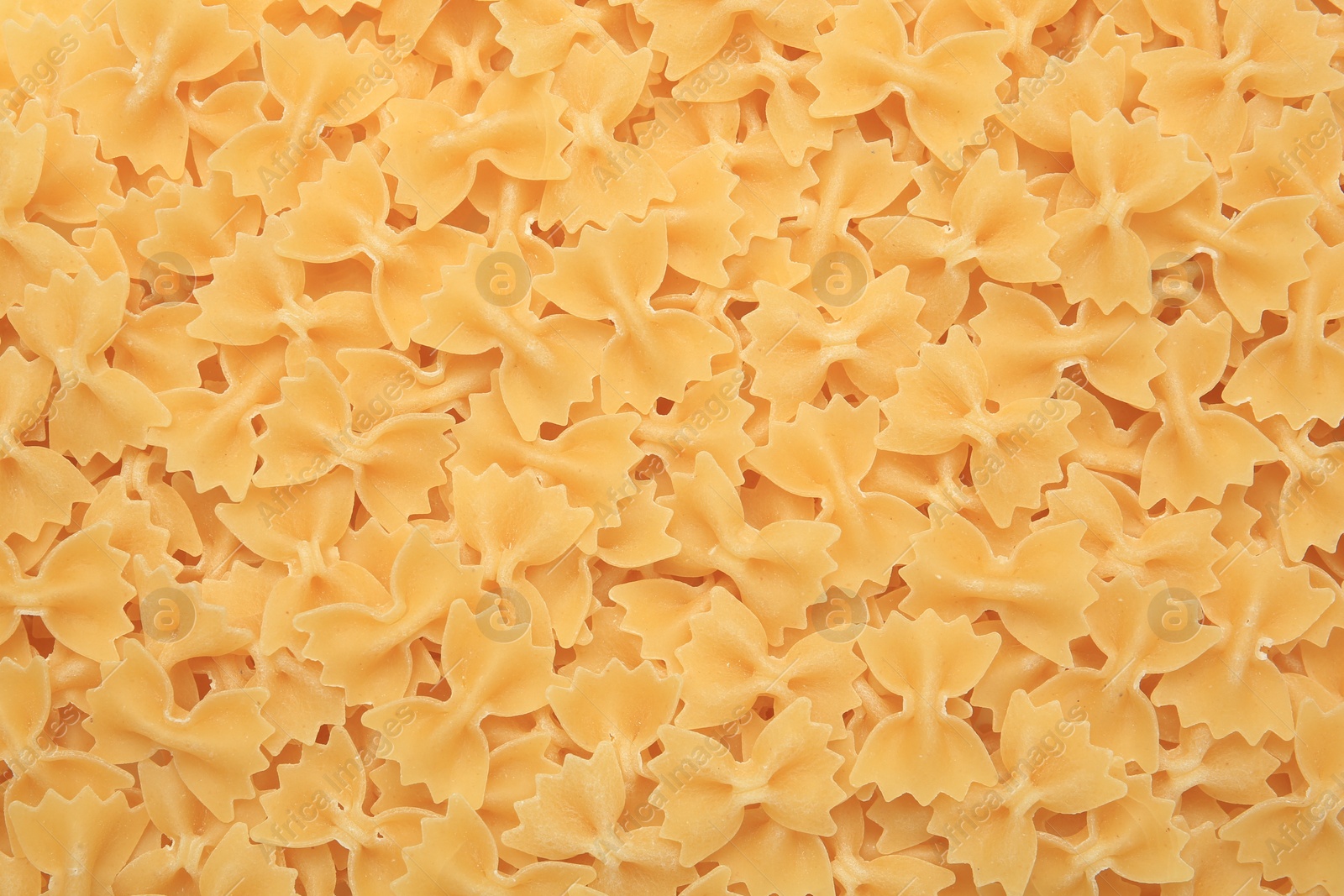 Photo of Raw farfalle pasta as background, top view