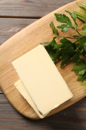 Photo of Tasty butter and parsley on wooden table, top view