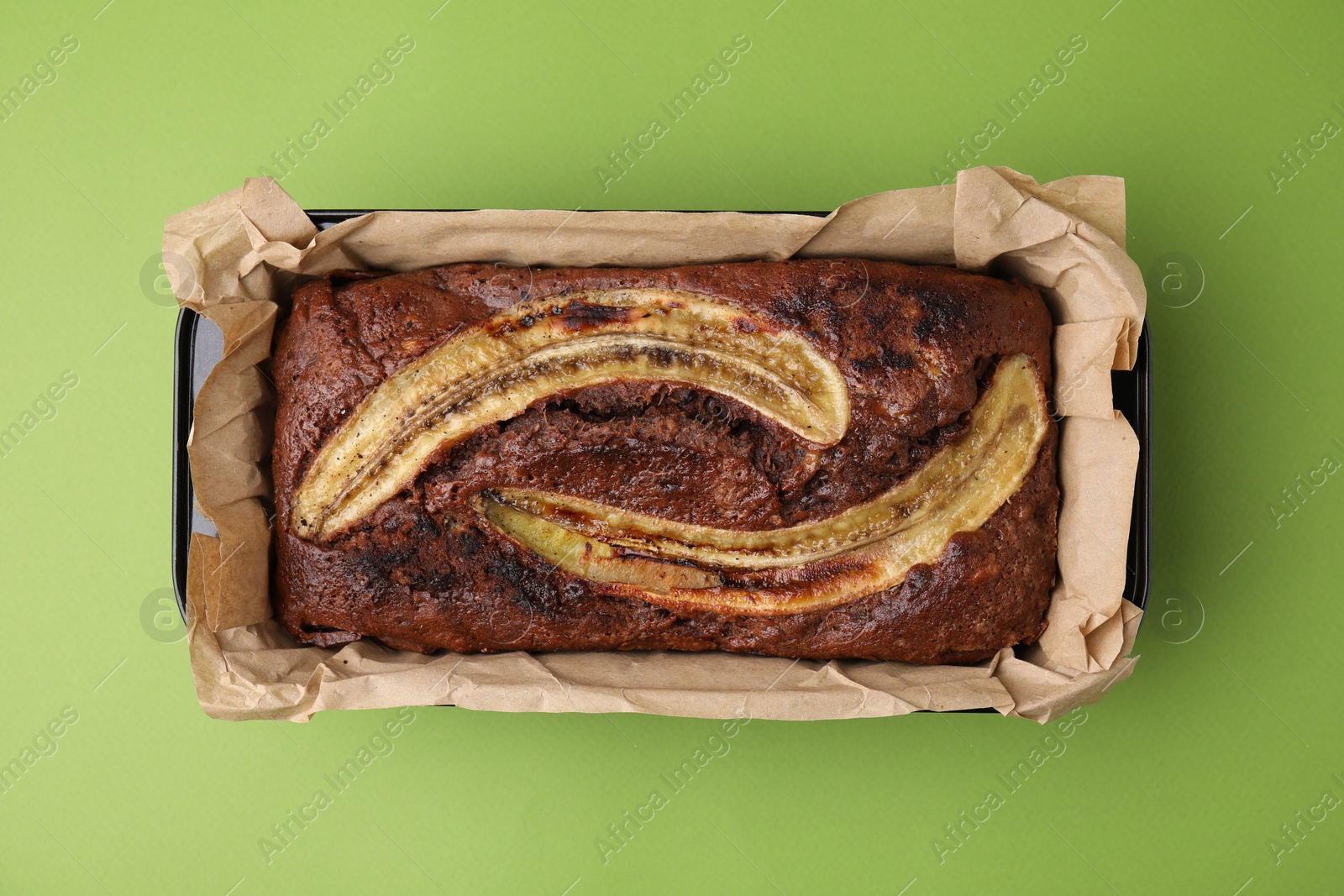Photo of Delicious banana bread on green background, top view