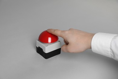 Photo of Man pressing red button of nuclear weapon on light gray background, closeup. War concept