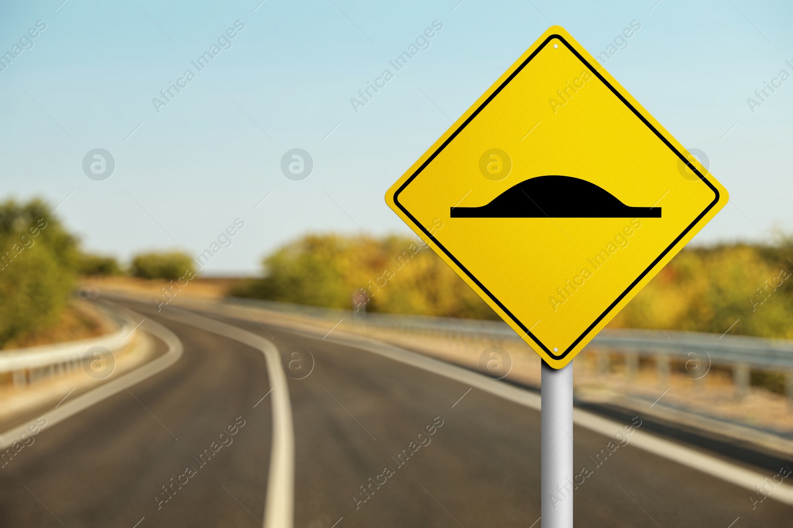 Image of Sign Speed Bump near asphalt road outdoors 