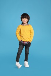 Photo of Full length portrait of cute little boy on light blue background