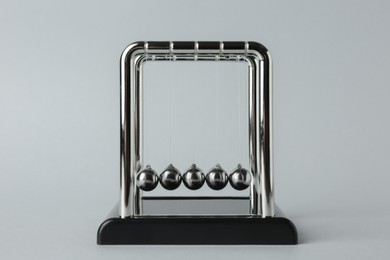 Newton's cradle on light background. Physics law of energy conservation