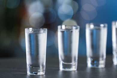 Shot of vodka on table against blurred background. Space for text