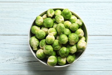 Bowl of fresh Brussels sprouts on wooden background, top view