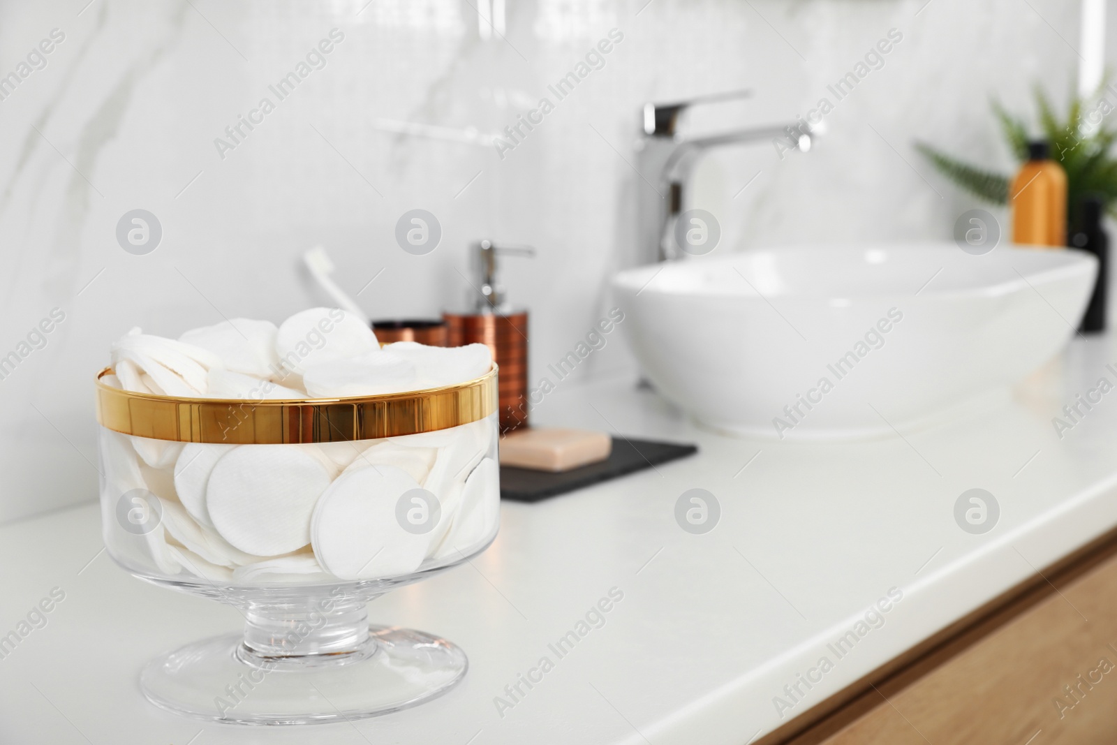 Photo of Jar with cotton pads on bathroom countertop