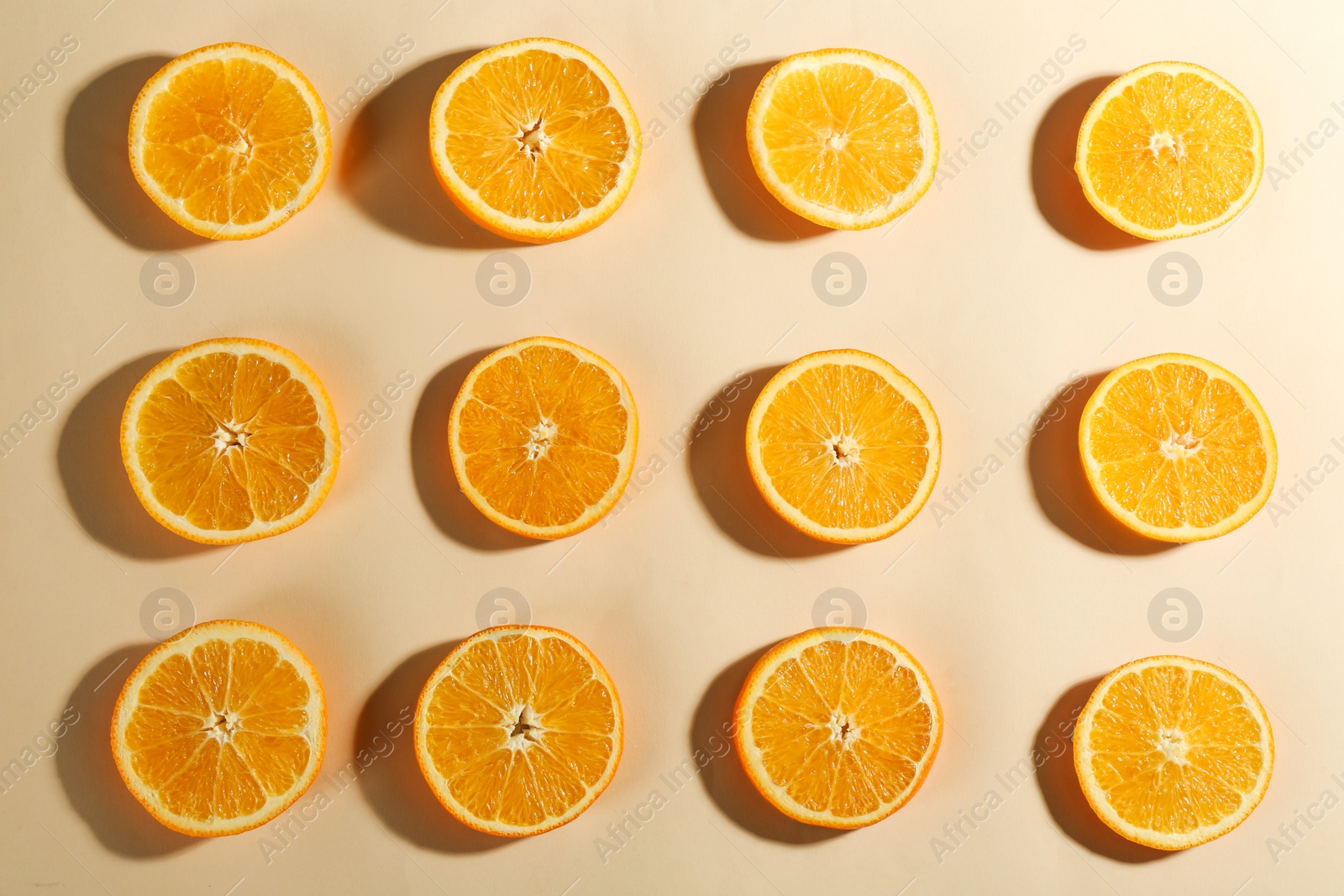 Photo of Slices of delicious oranges on beige background, flat lay