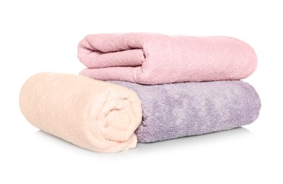 Photo of Folded and rolled soft terry towels on white background