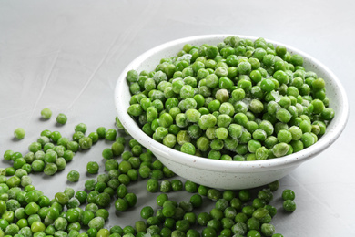Photo of Frozen peas on light grey table, closeup. Vegetable preservation