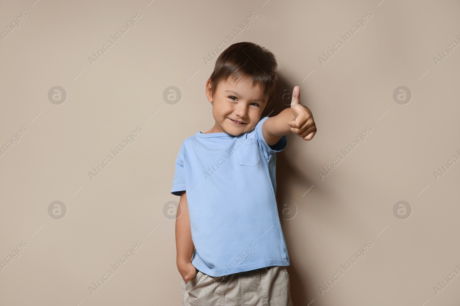 Photo of Portrait of cute little boy on beige background