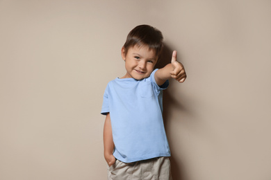 Portrait of cute little boy on beige background