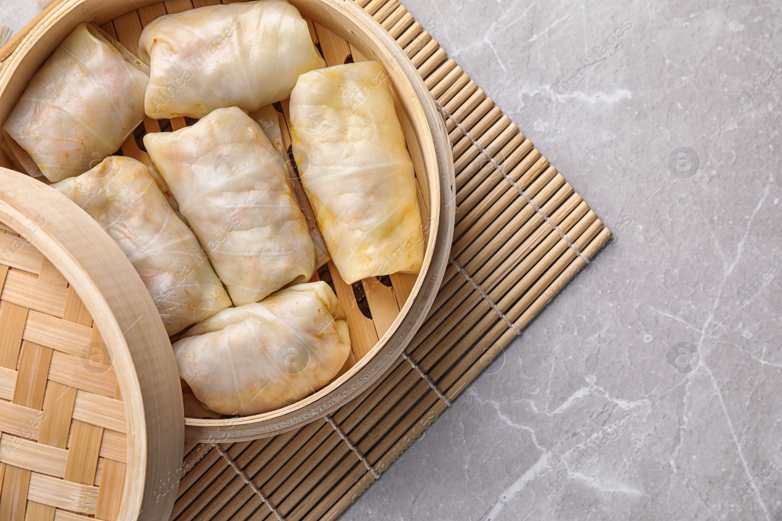 Photo of Delicious cabbage rolls served on light grey marble table, top view