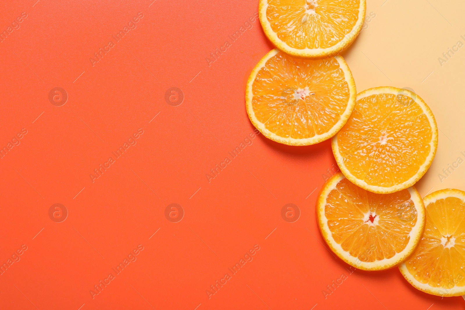 Photo of Slices of juicy orange on color background, top view. Space for text