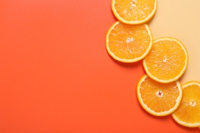 Photo of Slices of juicy orange on color background, top view. Space for text