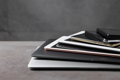 Photo of Many different modern gadgets on grey table. Space for text