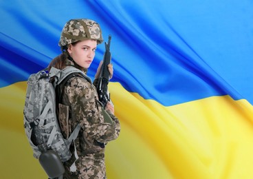 Armed soldier in military camouflage uniform and Ukrainian flag on background, space for text. Stop war