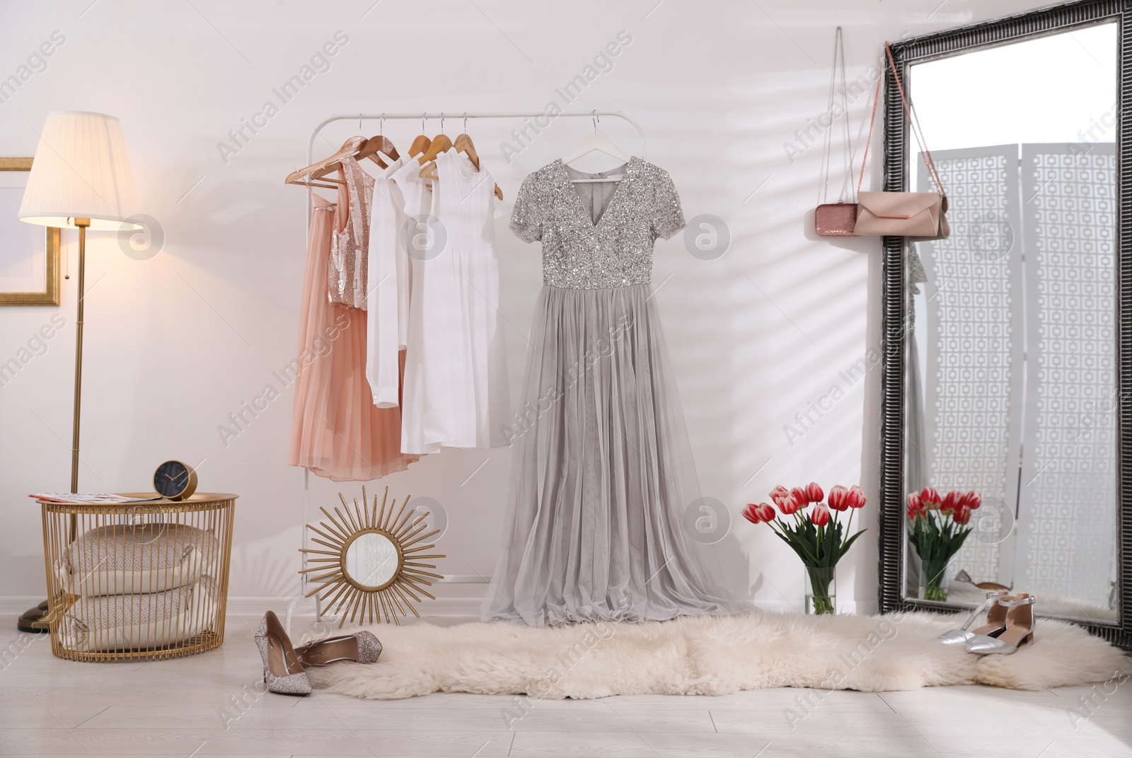 Photo of Rack with stylish women's clothes and mirror indoors. Interior design