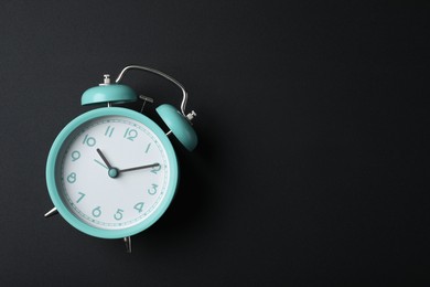 Photo of Alarm clock and space for text on black background, top view. School time