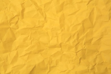 Sheet of crumpled orange paper as background, top view