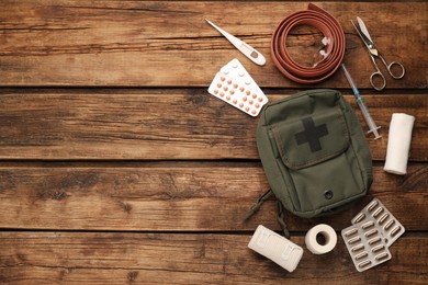 Photo of First aid kit on wooden table, flat lay. Space for text
