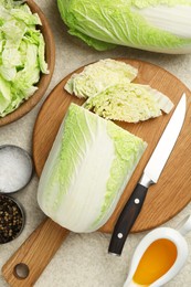 Photo of Fresh Chinese cabbages, oil and spices on light table, flat lay